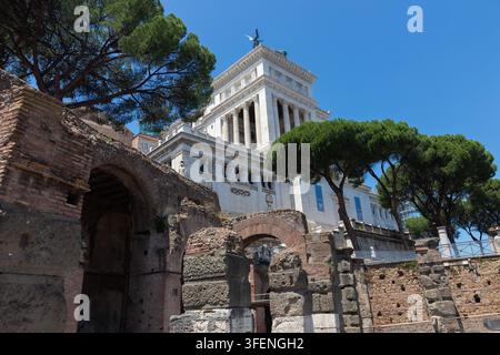 Antike römische Ruinen der Insula dell'Ara Coeli mit dem Altar des Vaterlandes im Hintergrund, Rom, Italien Stockfoto