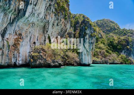 Dramatische Kalksteinklippe, die aus dem türkisfarbenen Tropenmeer in der Inselparadies erhebt Stockfoto