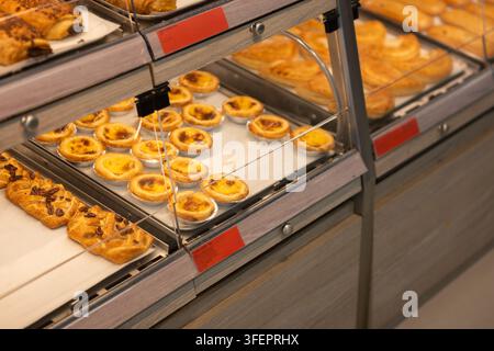 Kustertörtchen und verschiedene süße Gebäckstücke arrangiert in einer Einzelhandels-Bäckereivitrine Stockfoto