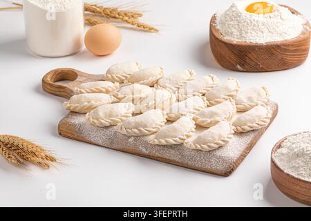 Rohe hausgemachte Vareniki-Teigtaschen auf Holzbrett Stockfoto