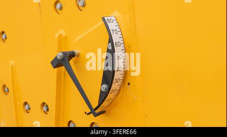 Nahaufnahme der Boom-Winkelanzeigeskala an gelbem Baumaschinenkran. Pendel-Inklinometer misst den Boom-Winkelgrad der schweren Position Stockfoto