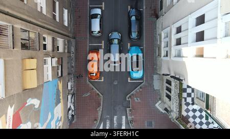 Luftbild des historischen Viertels Dorcol in Belgrad mit geparkten Autos entlang einer engen Straße und einem farbenfrohen Wandgemälde an der Seite eines Gebäudes Stockfoto