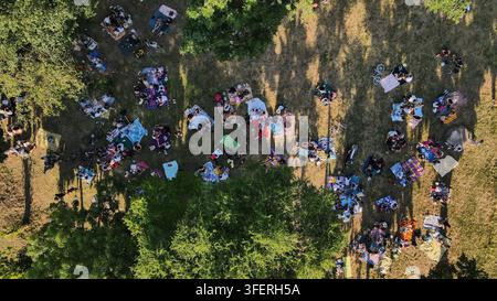 Luftbild des Usce-Parks in Belgrad, Stadt Belgrad, Serbien, mit zahlreichen Menschen, die auf Picknickdecken entspannen, die über den Rasen verteilt sind Stockfoto