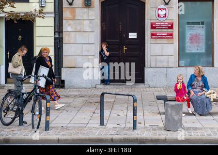 Warschau, Polen, 4. September 2026, Menschen und ein Fahrrad auf einem Fußgängersteig vor einem Gebäudeeingang Stockfoto
