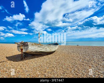 Verwittertes Holzfischerboot auf Kiesstrand in Aldeburgh bei ruhigem Meer unter blauem Himmel und vereinzelten Wolken Stockfoto