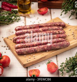 Rohe Rindfleischwürste auf einem Holzschneidebrett Stockfoto
