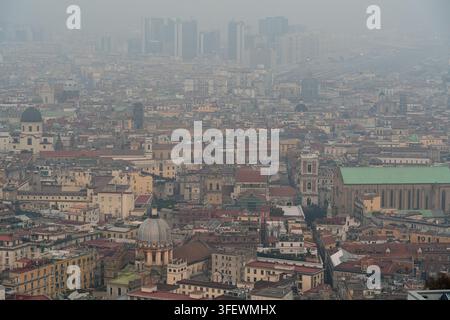 Ein stimmungsvoller Hochwinkelblick auf Neapel, Italien, vom Castel Sant'Elmo aus, der die dunstige historische Altstadt mit ihrer dichten Architektur und dem Duomo einfängt. Stockfoto