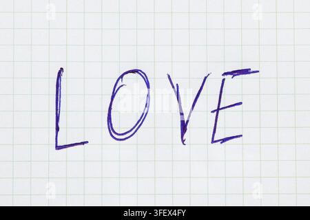Das Wort LIEBE, handgeschrieben mit blauem Stift auf einem Blatt kariertem Notizbuchpapier. Ein Symbol für Liebe und romantische Gefühle Stockfoto