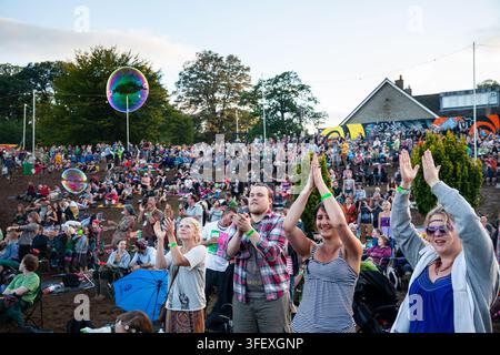 FREUDIGЕ FANS KLAPPEN AUF EINEM FESTIVAL, REPORTAGE, GREEN MAN FESTIVAL 2012, BRECON, WALES, UK, 2012: Eine freudige Menschenmenge klatscht in die Luft, während sie eine Aufführung auf einem großen Open-Air-Musikfestival beobachten, mit Seifenblasen, die am Himmel schweben. 19. August 2012. Foto: Rob Watkins. INFO: Das Green Man Festival findet jährlich im August in den Brecon Beacons statt. Es feiert alternative Musik, Kunst, Literatur und Wissenschaft in einer familienfreundlichen Bergumgebung. Das Festival 2012 war das schlammigste der Geschichte nach einer Woche starker Regenfälle. Stockfoto