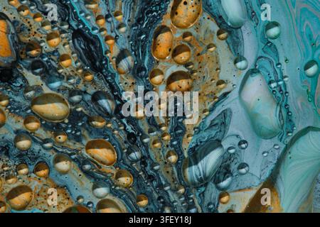 Abstrakte flüssige Kunsttextur mit blauen, orangefarbenen und grauen Wirbeln, die lebendige Öltropfenmuster erzeugen Stockfoto