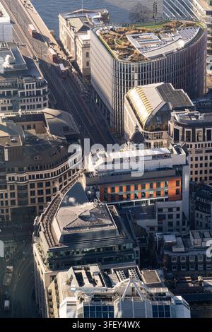 Rote Busse fahren die King William Street entlang, vorbei am Adelaide House in der City of London nahe der London Bridge während des morgendlichen Pendlerverkehrs. Stockfoto