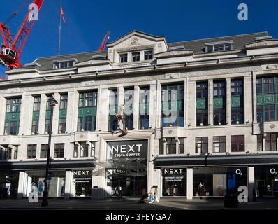 Einkäufer gehen an dem Next-Geschäft, Costa Coffee und Victoria's Secret auf der Oxford Street in London, UK, vorbei, um im berühmten Einzelhandelsviertel einzukaufen. Stockfoto