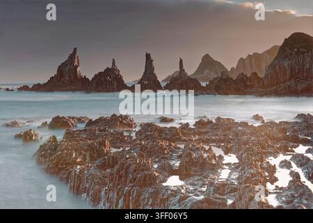 059 Langzeitbelichtungsbild – seidiger Wassereffekt = lebhafter Morgen über den scharfen Kliffen von Playa Gueirúa Beach, gestützt von einer dicken Wolke. Cudillero-Asturien-Spanien Stockfoto