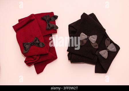 Farbige Mädchen-Baumwollsocken mit dekorativen Schleifen isoliert auf Weiß Stockfoto