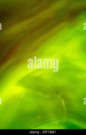 Ein dynamischer abstrakter Hintergrund mit einer Mischung aus lebendigen grünen und gelben Farben, der eine weiche, texturierte, rauchartige flüssige Bewegung aufweist, perfekt für Kreative Stockfoto