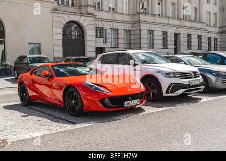Rotes Sportauto neben einem verzierten historischen Gebäude in Warschau geparkt Stockfoto