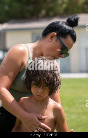 Mutter hält ihren Sohn, während sie gemeinsam Zeit im Freien verbringen während des Sommers Stockfoto