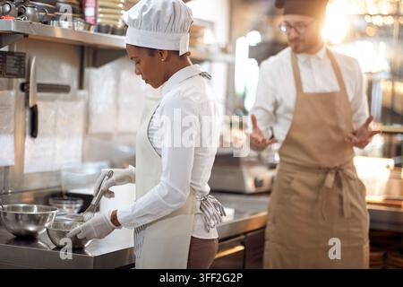 Koch, der Eier schlägt. Kochen in einer professionellen modernen Küche, Restaurantkonzept Stockfoto