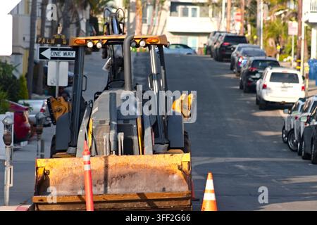 Ein Baggerlader steht mit Kegeln auf einer Stadtstraße in Hermosa Beach, Kalifornien. Stockfoto