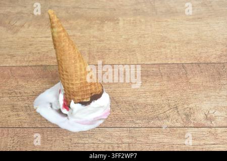 Erdbeergeschmack in einer Waffelkegel-Eiscreme, die fällt und auf den Boden fällt Stockfoto