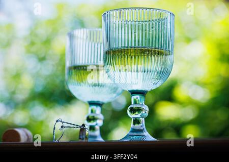 Sektgläser mit Korken auf einer sonnigen Gartenterrasse Stockfoto