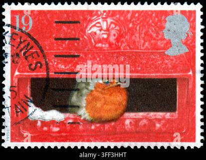 Weihnachtsbriefmarke Großbritanniens von 1995, die einen Rotkehlchen-Vogel in einem roten VR-Säulenbriefkasten zeigt. Stockfoto