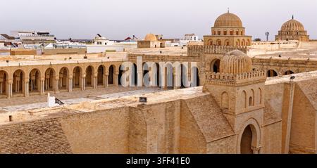 Nahaufnahme der kunstvollen Steinkuppeln, geschnitzten Portikusbögen und der großen Säulenhalle des historischen Großen Moschee von Kairouan, Tunesien unter Stockfoto