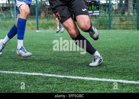 Kiew, Ukraine – 05. September 2026: Actionsaufnahme von Athleten, die während eines Mini-Fußball-Turnier-Spiels im Freien um die Wette sprinten, mit Anzeigetafel b Stockfoto