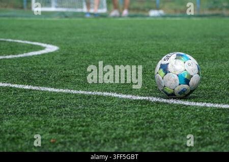 Kiew, Ukraine – 05. September 2026: Ein klassischer Futsalball ruht auf der weißen Linie des Kunstrasens während eines Mini-Football-Turniers. Stockfoto