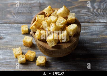 Hausgemachte Croutons in einer Holzschale auf einem rustikalen dunklen Holztisch Stockfoto