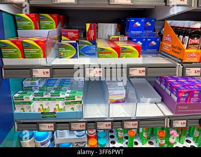Kalt- und Griperemedien sowie Paracetamol in den Regalen eines britischen Lidl-Discount-Supermarkts, wobei Preise und Markenmedikamente sichtbar sind. Stockfoto