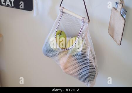 Obst in einem Netzbeutel, der an einer Wand hängt Stockfoto