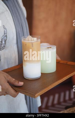 Ein Eiskaffee in einem hohen, klaren Glas auf einem Holzserviertablett Stockfoto