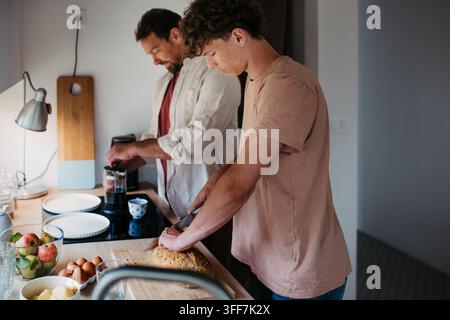 Teenager-Sohn hilft bei der Zubereitung des Frühstücks zu Hause. Stockfoto