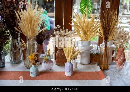 Ein getrocknetes Blumenarrangement Weizengras Pampasgras-Bouquet Keramikvase sonnenbeschienener Fenstertischaussteller mit neutraler Farbe rustikaler Textur böhmische Dekoration für Co Stockfoto
