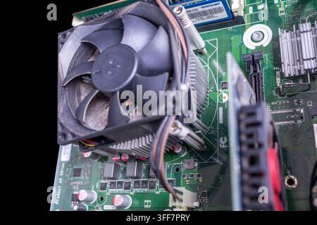 Nahaufnahme von starker Staubablagerung auf den Lüfterblättern eines Desktop-Computer-CPU, die die Notwendigkeit von Hardware-Wartung und Reinigung zur Vermeidung von Überhitzung hervorhebt Stockfoto