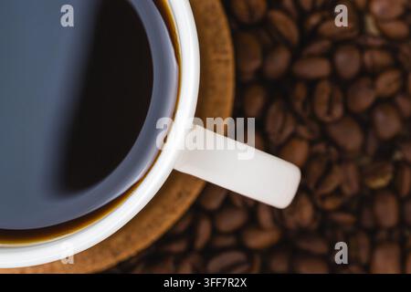 Oberansicht von schwarzem Kaffee und gerösteten Bohnen für Frühstücks- und Koffeinkonzepte Stockfoto