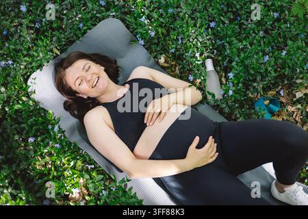 Schwangere Frau, die im Freien Fitness macht. Stockfoto