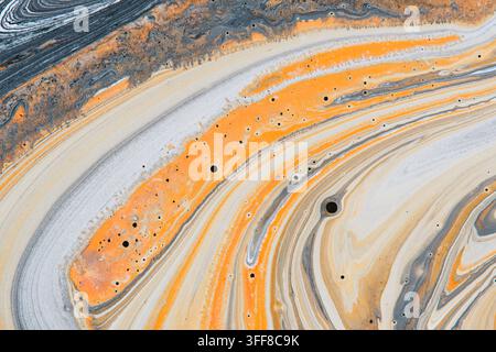 Weiche abstrakte flüssige Kunsttextur mit sanften orangefarbenen und hellgrauen wirbelnden Acrylfarbwellen Stockfoto