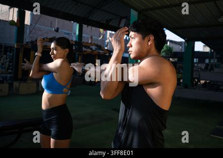Junger athletischer Mann und Frau dehnen sich vor dem Training. Stockfoto
