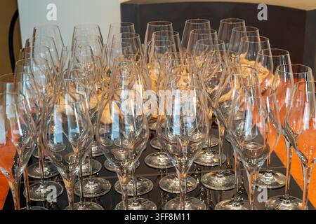 Reihen klarer Weingläser auf glänzender schwarzer Oberfläche Stockfoto