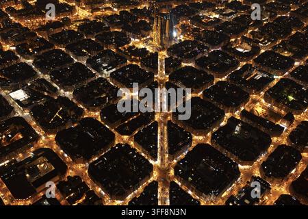 Luftbild der beleuchteten Sagrada Familia, umgeben von den rasterartigen Stadtblöcken des Eixample-Viertels in Barcelona, Katalonien, Spanien. Stockfoto