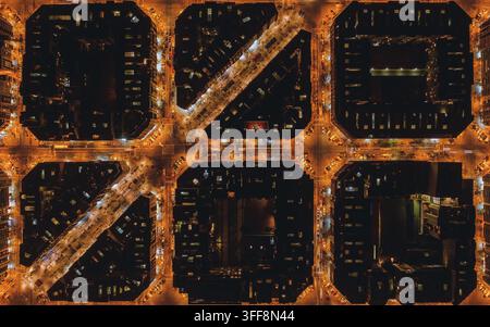 Luftbild des Eixample-Viertels bei Nacht, das das ikonische Raster der Stadtblöcke mit beleuchteten Straßen und Gebäuden in Barcelona zeigt, Kat Stockfoto