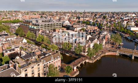 Luftbild der Amstel und der angrenzenden Kanäle, Brücken und historischen Häuser im Zentrum von Amsterdam, Niederlande. Stockfoto