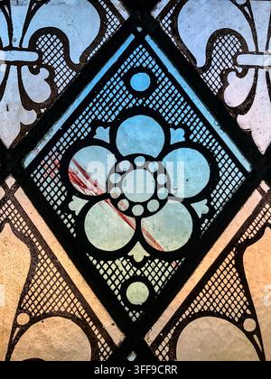 Nahaufnahme eines hellblauen Blumenmusters und geometrischer Bleiglasarbeiten in einem historischen Buntglasfenster in der Evans Memorial Chapel der University of Den Stockfoto