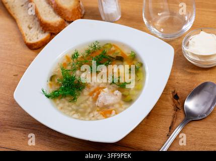 Leckere Suppe Rassolnik serviert in einer Schüssel auf dem Tisch, dekoriert mit Petersilie. Traditionelles russisches Gericht Stockfoto