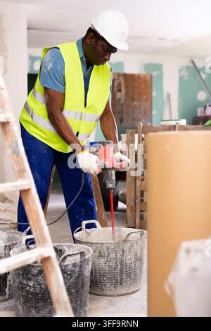 Porträt eines afroamerikanischen Baumeisters, der im Reparaturprozess arbeitet Stockfoto