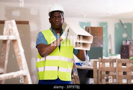 Porträt eines afroamerikanischen Baumeisters, der im Reparaturprozess arbeitet Stockfoto