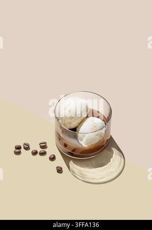 Affogato-Kaffee mit Vanilleeiswürfeln und Espresso in einem Glas auf hellem Hintergrund mit Kaffeebohnen und Schatten. Klassisches italienisches Dessert con Stockfoto