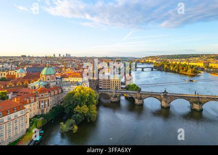 Die ikonische Karlsbrücke erstreckt sich über die Moldau und verbindet das historische Prag. Diese lebendige Luftaufnahme fängt die schöne Stadtsilhouette bei Su Stockfoto